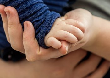 Toddler holding a parent's hand
